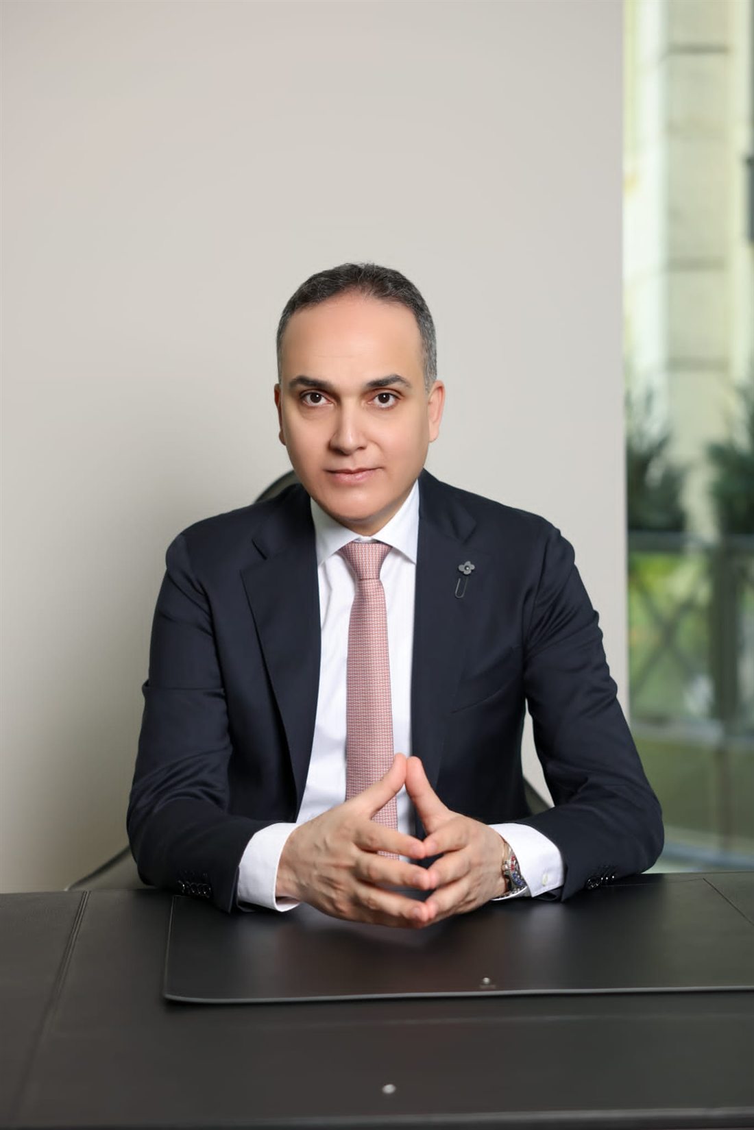 Portrait of Ahmed Gadalla seated at an executive desk
